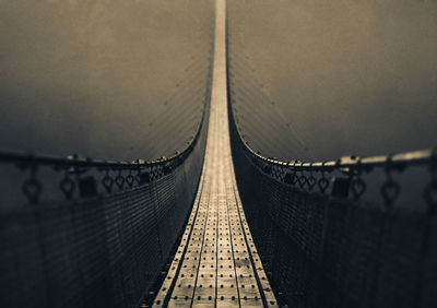 Footbridge in city against sky