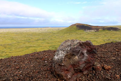 Scenic view of rocks on field against sky