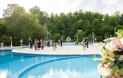 People in swimming pool against trees