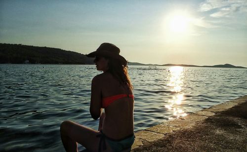 Silhouette of woman standing at sunset