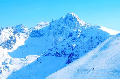 Scenic view of snowcapped mountains against clear blue sky