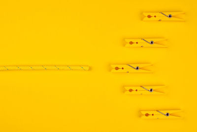 High angle view of colored pencils against yellow wall