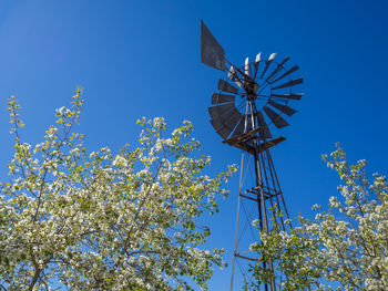 Low angle view of traditional windmill against blue sky