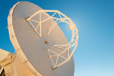 Low angle view of traditional windmill against clear blue sky