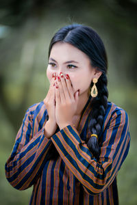 Portrait of young woman standing outdoors