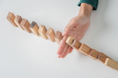 Close-up of hand holding paper against white background