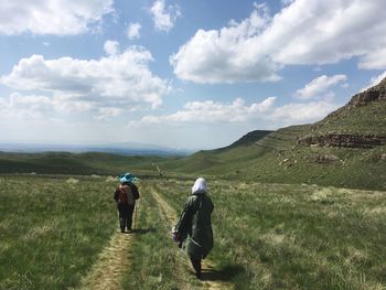 Rear view of men walking on trail