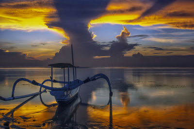 Scenic view of sea against dramatic sky during sunset