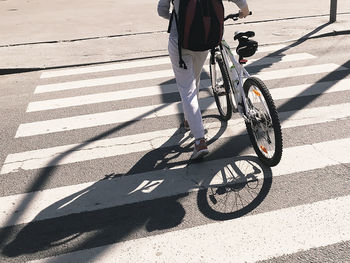 Low section of person riding bicycle on road