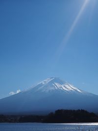 Scenic view of snowcapped mountains against blue sky