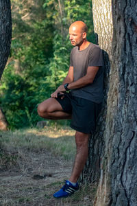 Full length of man making tree trunk in forest