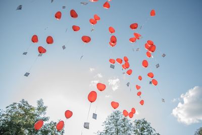 Low angle view of balloons flying against sky