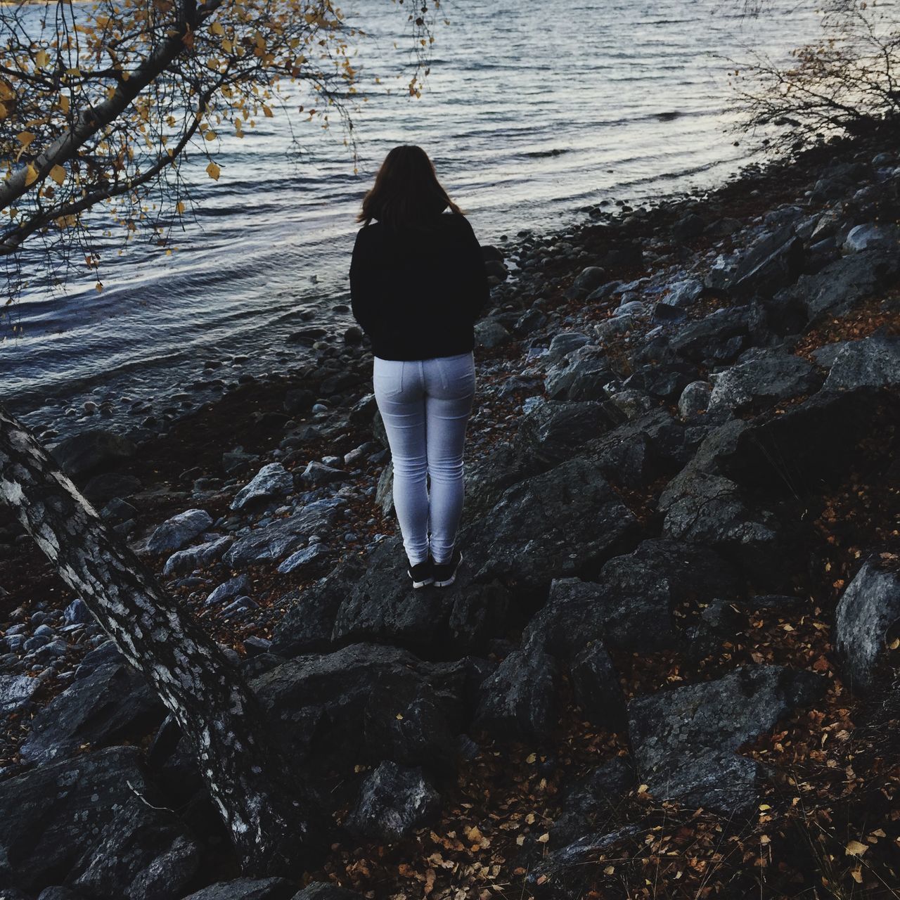 water, lifestyles, leisure activity, tranquility, standing, tranquil scene, nature, rear view, rock - object, beauty in nature, person, outdoors, scenics, full length, reflection, vacations, day, high angle view