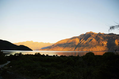 Scenic view of lake and mountains against clear sky