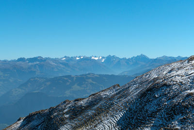 Scenic view of snowcapped mountains against clear blue sky