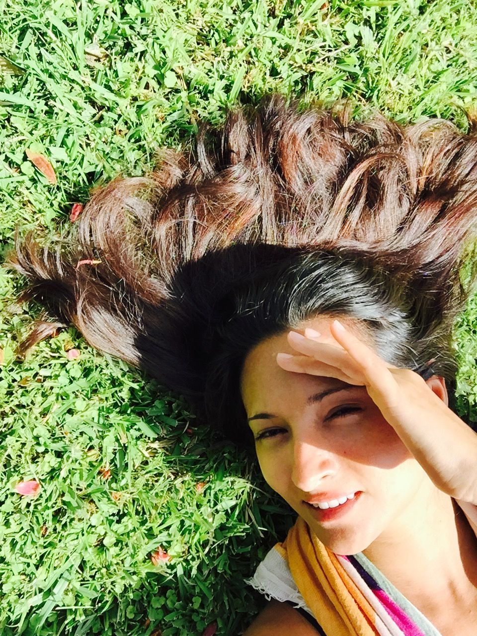 grass, person, portrait, looking at camera, smiling, green color, lifestyles, high angle view, leisure activity, young women, field, headshot, plant, growth, young adult, front view, grassy, day