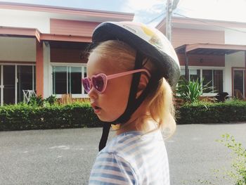 Side view of girl wearing sunglasses standing by road