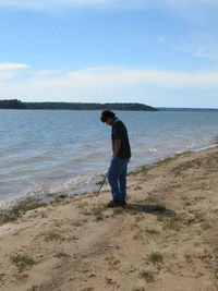 Full length of man standing on beach against sky