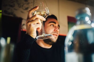 Close-up portrait of young man with drinking glass