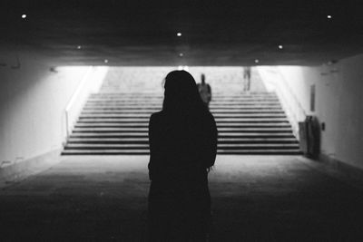 Rear view of silhouette woman walking on stairs