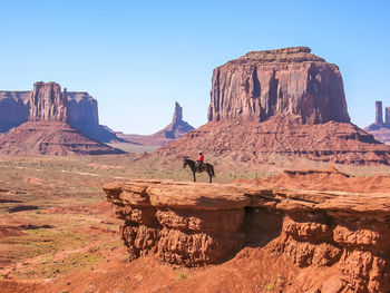 Man on cliff against clear sky