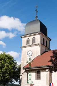 Low angle view of clock tower by building against sky