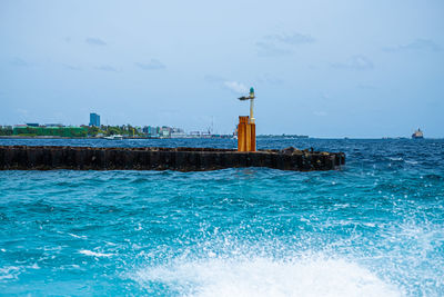 Lighthouse by swimming pool against sky