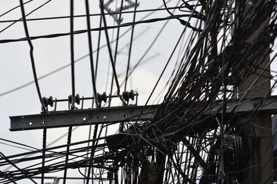 Low angle view of men working on bridge against sky