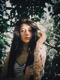 Portrait of young woman against trees