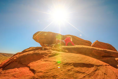 Low angle view of leaf on rock against sky on sunny day