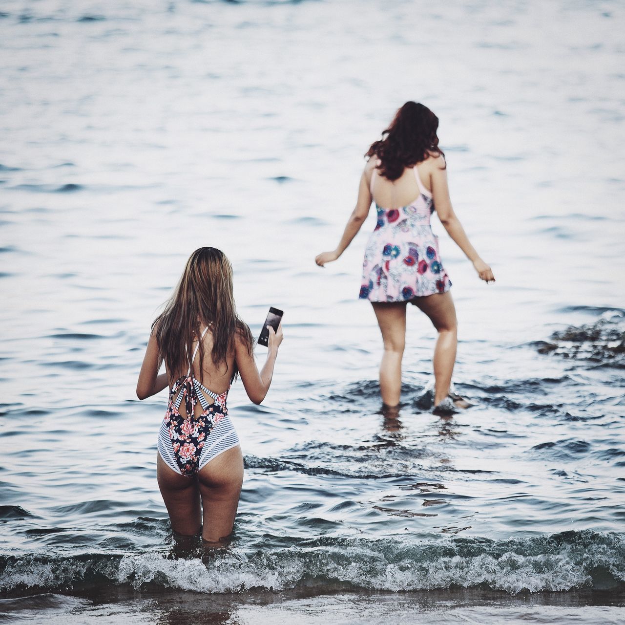 water, real people, women, lifestyles, leisure activity, full length, two people, people, long hair, togetherness, rear view, sea, adult, child, family, day, nature, swimwear, hairstyle, hair, outdoors, sister