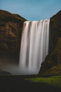 Scenic view of waterfall against sky