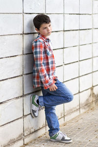 Teenager boy standing by wall