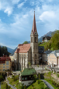 Buildings in city against cloudy sky