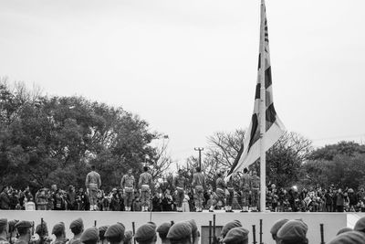 Group of people at cemetery against clear sky