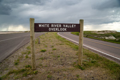 Information sign on road against sky