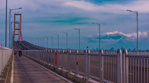 Bridge over street against sky at dusk