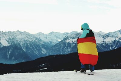 Rear view of man walking on snow covered mountain