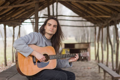 Portrait of a young woman playing guitar