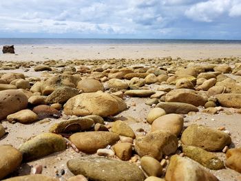Pebbles on beach against sky