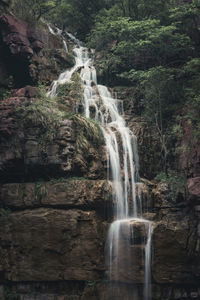 Low angle view of waterfall on mountain