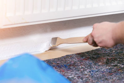 Cropped hand of worker painting