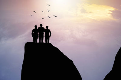 Silhouette people standing against sky during sunset