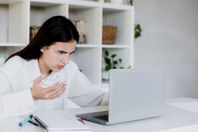 Angry unhappy young woman at home office desk work online on computer, have problems with device