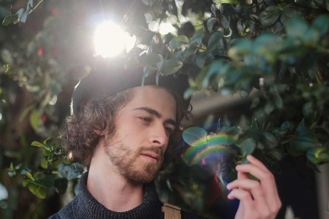headshot, portrait, one person, young adult, plant, leisure activity, lifestyles, nature, beard, young men, sunlight, day, real people, lens flare, front view, facial hair, growth, holding, outdoors