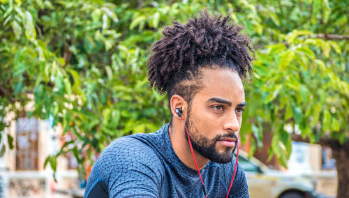 Young man looking away while listening music