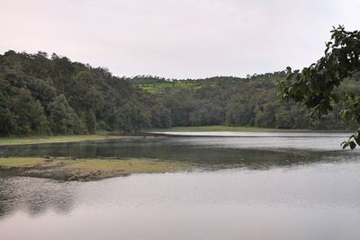 Scenic view of lake by trees against sky