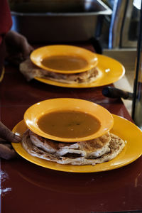 Midsection of person preparing food in plate on table