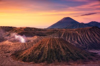 Panoramic view of volcanic crater against sky during sunset