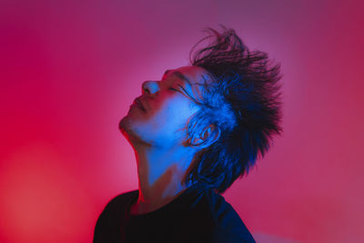 Portrait of young man against pink background